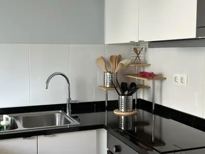 a kitchen with white cabinets and a sink at Cozy Duplex Retreat by Green Park & Ocean View in Funchal