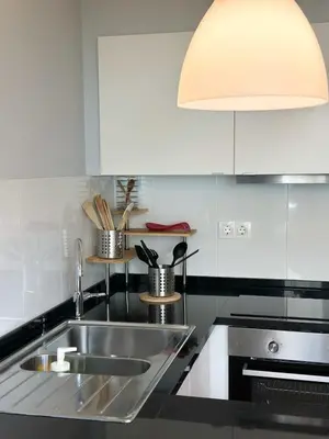a kitchen with a stainless steel sink and a lamp at Cozy Duplex Retreat by Green Park & Ocean View in Funchal