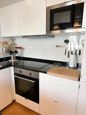 a kitchen with white cabinets and a microwave at Cozy Duplex Retreat by Green Park & Ocean View in Funchal