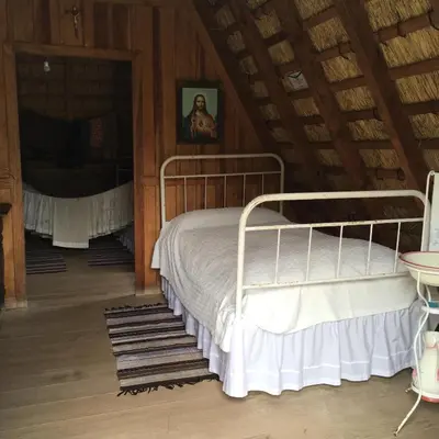 a bed in a room with a wooden ceiling at Casa do Til in Santana