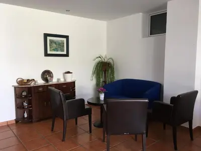 a room with a table and chairs and a blue couch at Casa do Til in Santana
