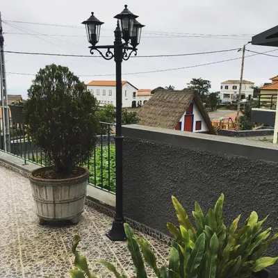 a street light and a potted tree on a balcony at Casa do Til in Santana