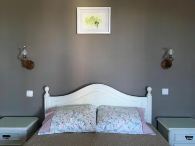 a bedroom with a bed with two tables and a picture on the wall at Casa do Til in Santana