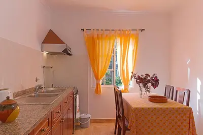 a kitchen with a sink and a table and a window at Casa Alto Santo António in Ponta do Sol