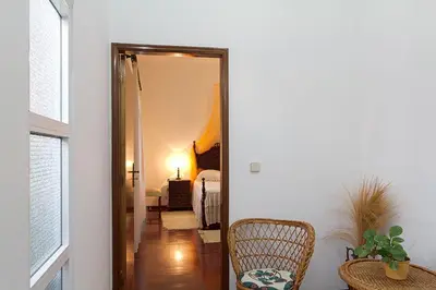a hallway with a mirror and a chair in a room at Casa Alto Santo António in Ponta do Sol