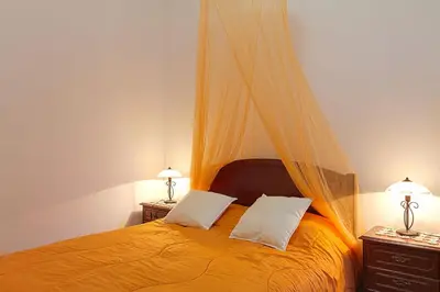 a bedroom with an orange bed with two night stands at Casa Alto Santo António in Ponta do Sol