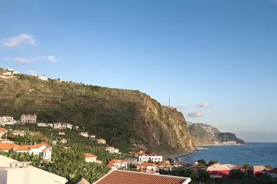 a town on a hill next to the ocean at Casa Alto Santo António in Ponta do Sol