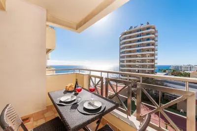 a balcony with a table with two glasses of wine at Falesia Apartment by LovelyStay in Funchal