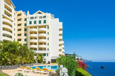a hotel with a swimming pool next to the ocean at Falesia Apartment by LovelyStay in Funchal