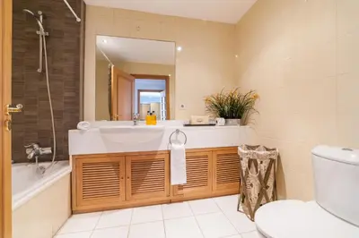 a bathroom with a sink and a tub and a toilet at Falesia Apartment by LovelyStay in Funchal