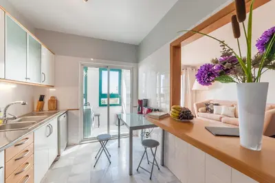 a kitchen with a table with purple flowers on it at Falesia Apartment by LovelyStay in Funchal