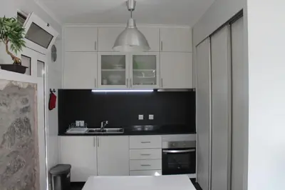 a kitchen with white cabinets and a sink at Casa da Fininha in Calheta