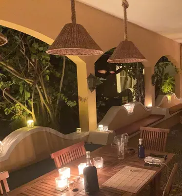 a table in a restaurant with two hanging lights at Villa Ines, at the beach in Porto Santo