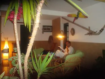 a man sitting in a chair in a living room at Villa Ines, at the beach in Porto Santo