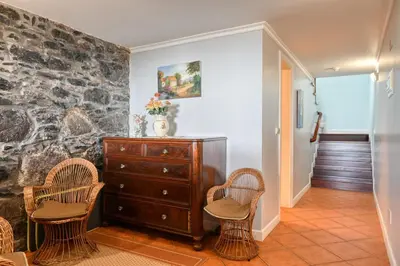 a living room with two chairs and a dresser at Casa do Pombal, a Home in Madeira in Arco da Calheta