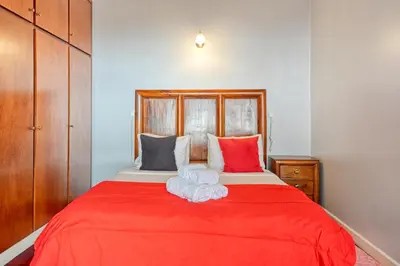 a bedroom with a red bed with two towels on it at Casa do Pombal, a Home in Madeira in Arco da Calheta