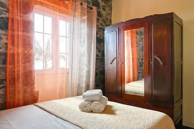 two towels sitting on a bed in front of a mirror at Casa do Pombal, a Home in Madeira in Arco da Calheta