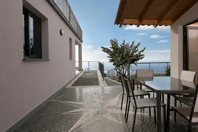 a white dining room with a white table and chairs at Villa Guiné in Arco da Calheta