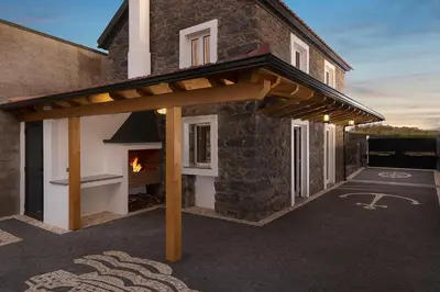 a wooden pergola on the side of a house at Casa do Leme in Arco da Calheta