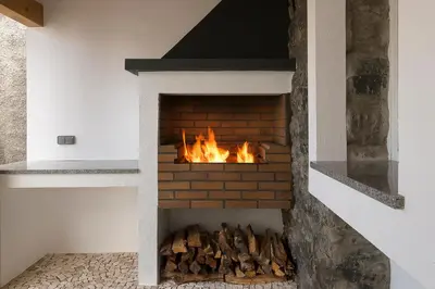a brick fireplace with a fire in it at Casa do Leme in Arco da Calheta