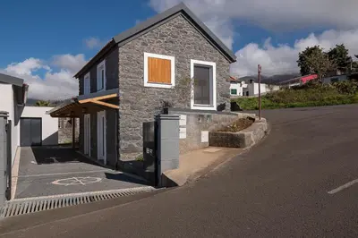 a stone house on the side of a street at Casa do Leme in Arco da Calheta