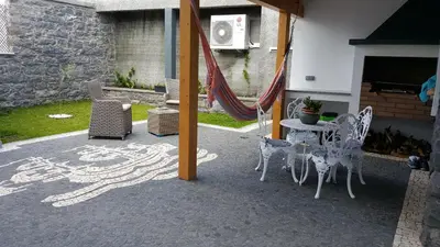 a patio with a hammock and a table and chairs at Casa do Leme in Arco da Calheta