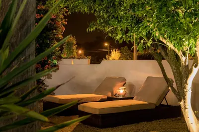 a patio with two chairs and a table under a tree at Casa Luisandra Boutique Hotel B&B in Luz