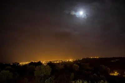 a full moon rising over a city at night at Casa Luisandra Boutique Hotel B&B in Luz