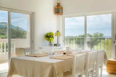 a dining room with a table and chairs and windows at Casa Luisandra Boutique Hotel B&B in Luz
