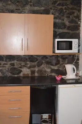 a kitchen with a counter with a microwave and a chair at Central Suite in Funchal 1N in Funchal