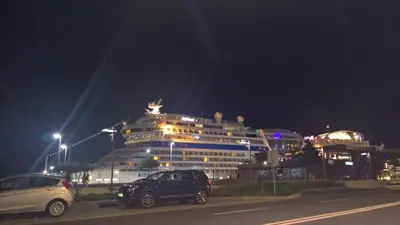 a cruise ship at night with cars parked in front at Central Suite in Funchal 2N in Funchal
