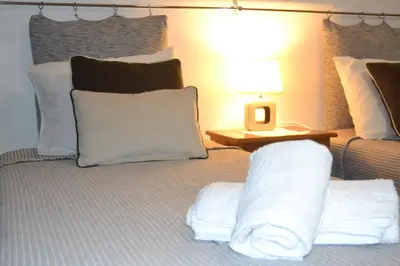 a bed with white pillows and a table with a lamp at Central Suite in Funchal 2N in Funchal