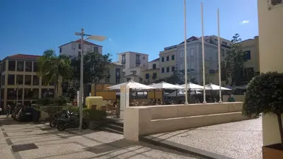 a group of tables and umbrellas in a city at Central Suite in Funchal 3N in Funchal