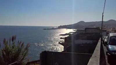 a view of the ocean with cars parked on a retaining wall at Central Suite in Funchal 3N in Funchal