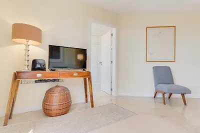 a living room with a table and a television and a chair at Funchal Marina Bay in Funchal