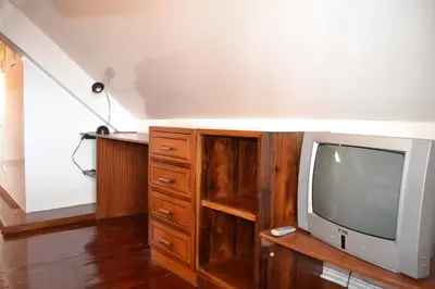 a living room with a tv and a wooden entertainment center at Central Studio in Funchal 3S in Funchal
