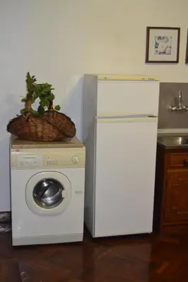 a white refrigerator and a washing machine with a basket on top at Central Studio in Funchal 3S in Funchal