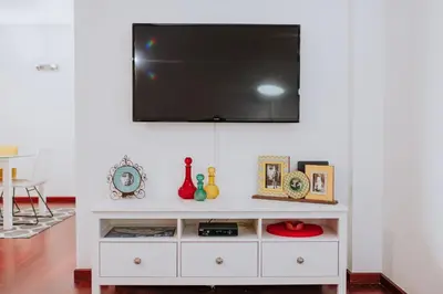 a white entertainment center with a flat screen tv on a wall at Funchal Old Town Bay View 3.1 in Funchal