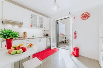 a white kitchen with a bowl of fruit on a counter at Funchal Old Town Bay View 3.1 in Funchal