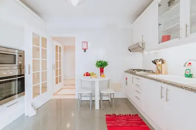 a kitchen with white cabinets and a white table at Funchal Old Town Bay View 3.1 in Funchal