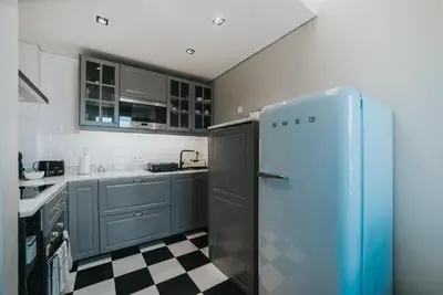 a kitchen with a refrigerator and a checkered floor at Mansarda dos Aranhas by Madeira Best Apartments in Funchal