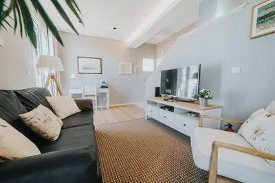 a living room with a black couch and a flat screen tv at Mansarda dos Aranhas by Madeira Best Apartments in Funchal