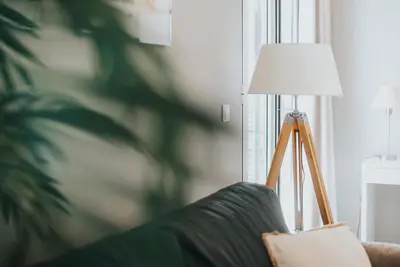 a lamp sitting on a couch next to a window at Mansarda dos Aranhas by Madeira Best Apartments in Funchal