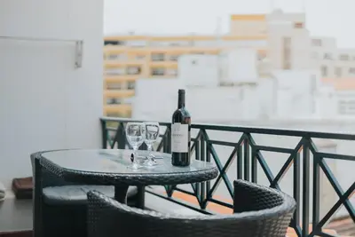 a table with a bottle of wine and two glasses at Mansarda dos Aranhas by Madeira Best Apartments in Funchal