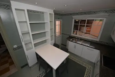 a small kitchen with a white table and a window at Villa Chaves in Funchal