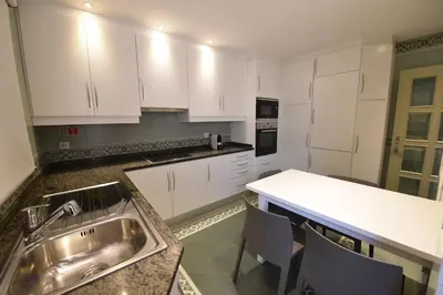 a kitchen with white cabinets and a sink at Villa Chaves in Funchal