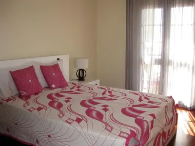 a bedroom with a large bed with red pillows at Casa Maresia- Sea view & Private pool in Ponta do Sol