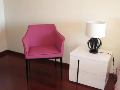 a pink chair sitting next to a lamp on a nightstand at Casa Maresia- Sea view & Private pool in Ponta do Sol