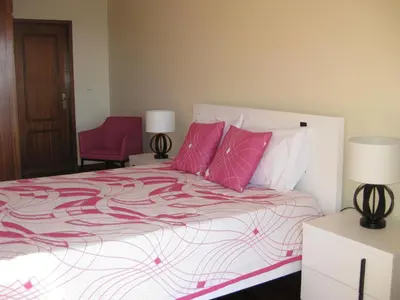 a bedroom with a large bed with pink pillows at Casa Maresia- Sea view & Private pool in Ponta do Sol