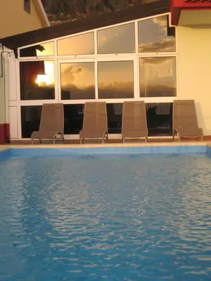 an empty swimming pool with chairs in front of a building at Casa Maresia- Sea view & Private pool in Ponta do Sol